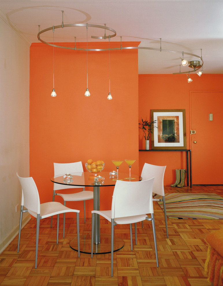 This is an example of a contemporary dining room in New York with orange walls.