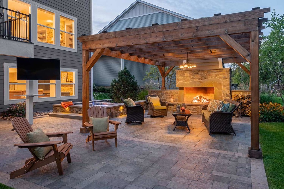Photo of a large country backyard patio in Minneapolis with with fireplace and natural stone pavers.
