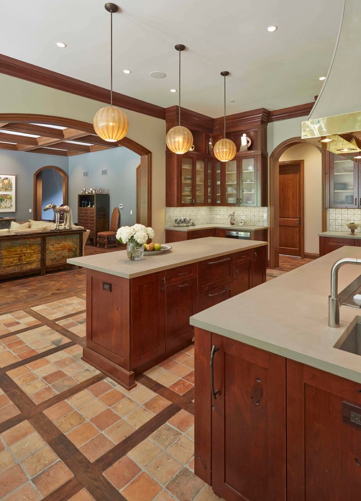 This is an example of an expansive traditional galley eat-in kitchen in Chicago with shaker cabinets, dark wood cabinets, soapstone benchtops, white splashback, ceramic splashback, stainless steel appliances, terra-cotta floors and multiple islands.