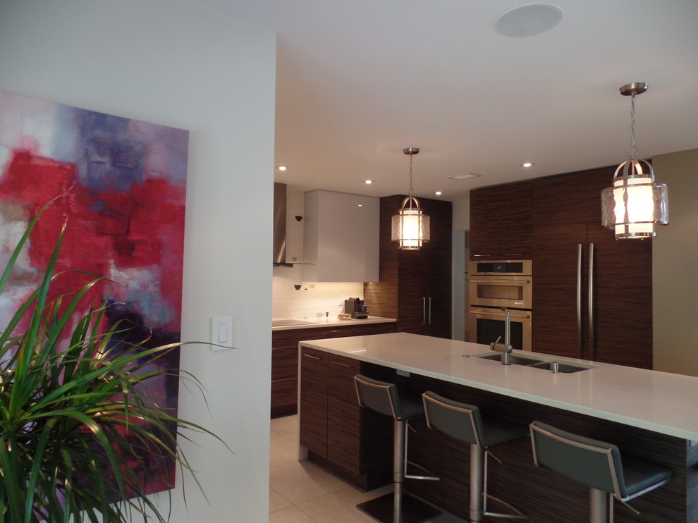 Enclosed kitchen - mid-sized transitional l-shaped porcelain tile and beige floor enclosed kitchen idea with an undermount sink, flat-panel cabinets, medium tone wood cabinets, quartz countertops, white backsplash, subway tile backsplash, paneled appliances and an island