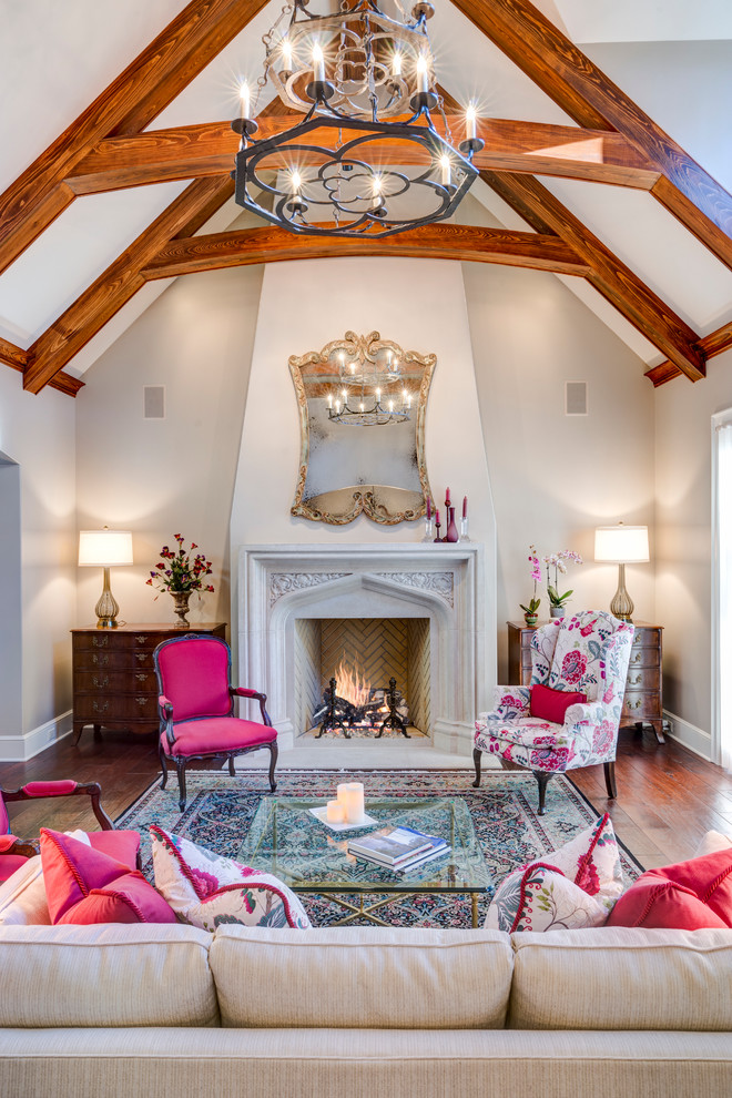 This is an example of a large transitional formal enclosed living room in Other with beige walls, medium hardwood floors, a standard fireplace, a plaster fireplace surround and no tv.