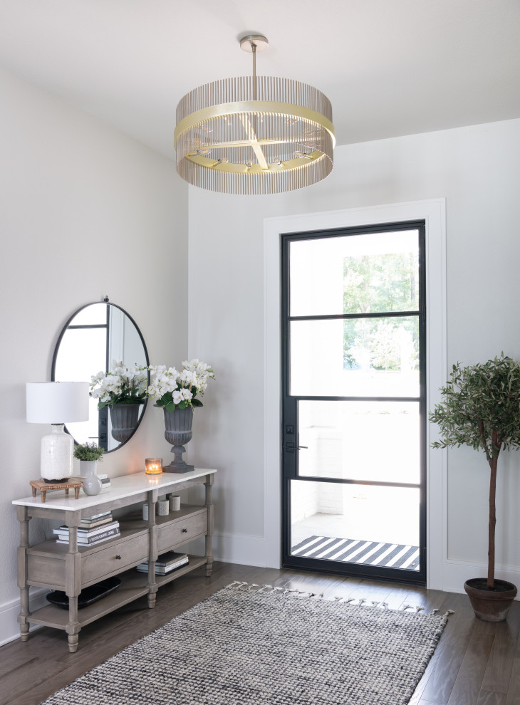 This is an example of a mid-sized beach style entry hall in Dallas with grey walls, porcelain floors, a pivot front door, a black front door and brown floor.