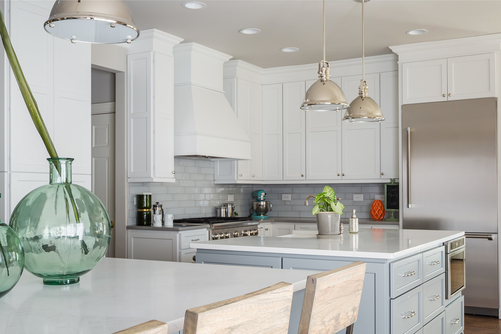 Example of a huge transitional galley medium tone wood floor open concept kitchen design in Raleigh with a farmhouse sink, flat-panel cabinets, white cabinets, quartz countertops, gray backsplash, ceramic backsplash, stainless steel appliances and two islands