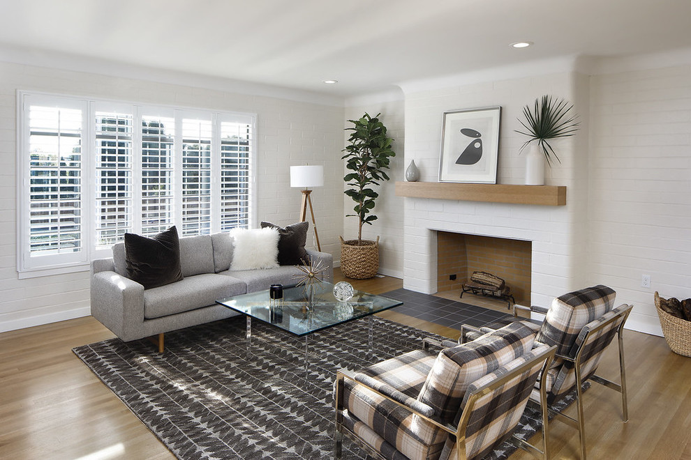 Living room - transitional medium tone wood floor and brown floor living room idea in San Francisco with white walls, a standard fireplace and a brick fireplace