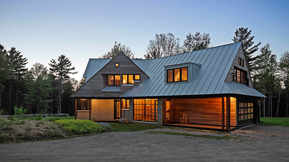 Photo of a mid-sized country two-storey brown house exterior in Orange County with wood siding, a gable roof and a metal roof.