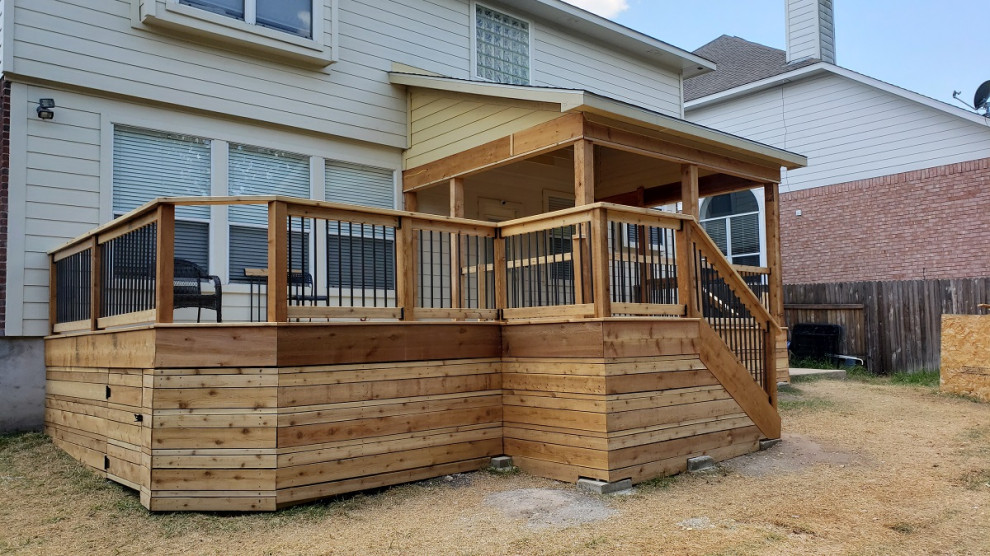 Inspiration for an expansive country backyard deck in Austin with with skirting, a roof extension and mixed railing.
