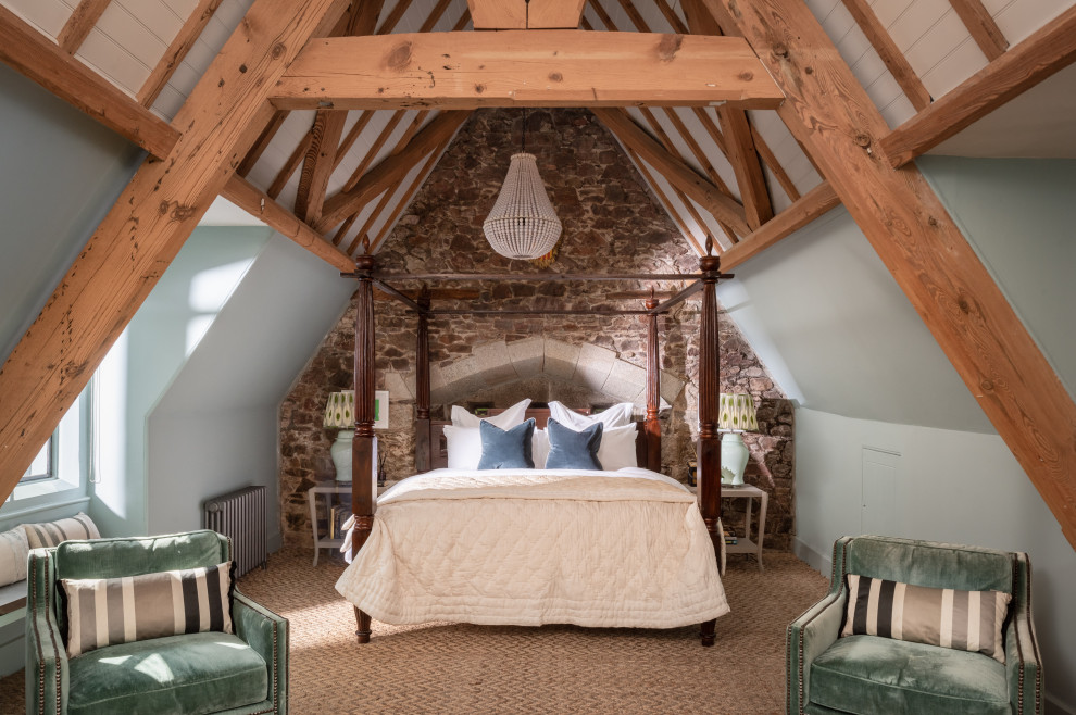 This is an example of a large traditional master bedroom in Cornwall with blue walls, carpet, beige floor and brick walls.
