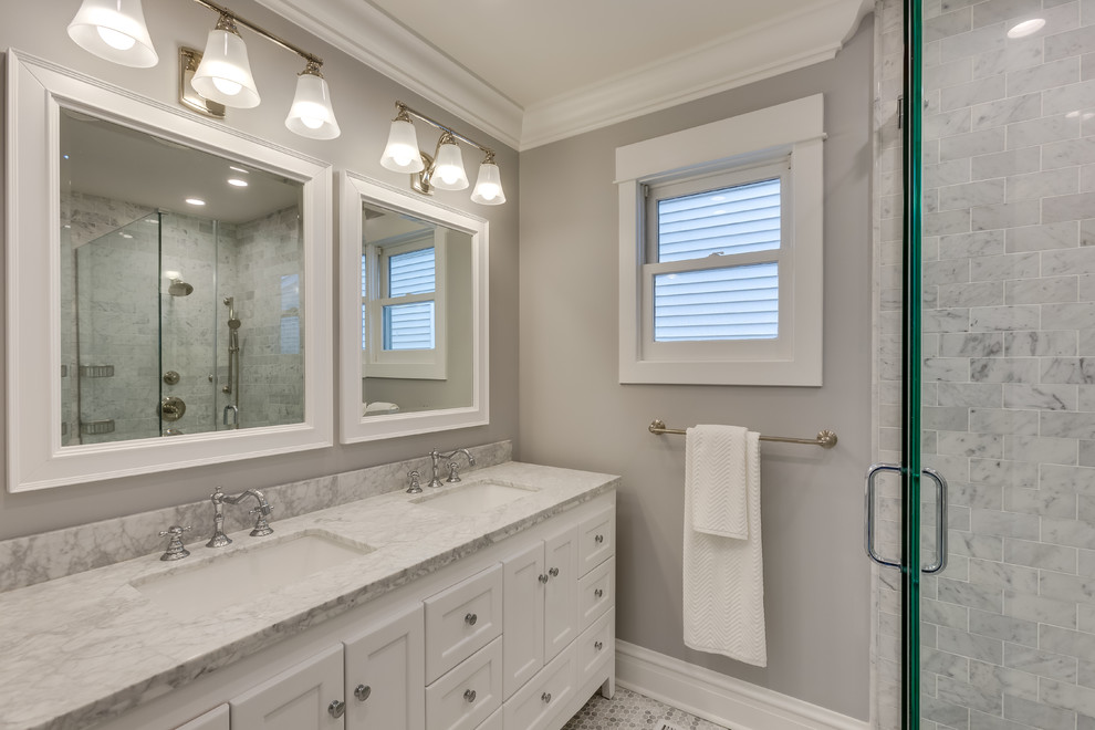 Design ideas for a large transitional bathroom in Chicago with recessed-panel cabinets, white cabinets, an alcove tub, a shower/bathtub combo, a two-piece toilet, white tile, subway tile, grey walls, an undermount sink, marble benchtops and multi-coloured floor.