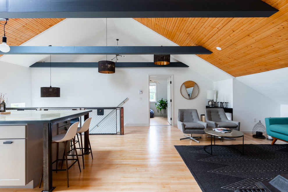 Mittelgroßes Industrial Wohnzimmer im Loft-Stil mit weißer Wandfarbe, hellem Holzboden, Kaminofen, Kaminumrandung aus Stein, TV-Wand und freigelegten Dachbalken in Portland Maine