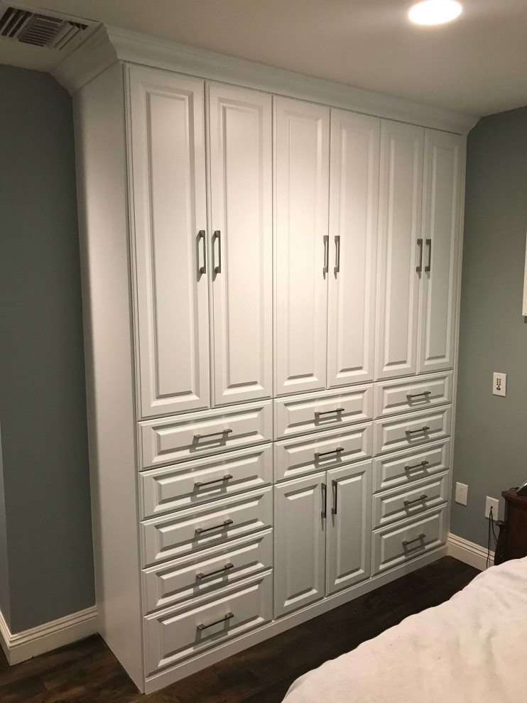 Example of a mid-sized arts and crafts gender-neutral built-in closet design in Orange County with raised-panel cabinets and white cabinets