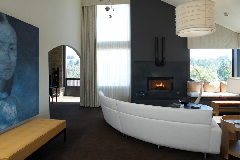 This is an example of a contemporary living room in San Francisco with a concrete fireplace surround.