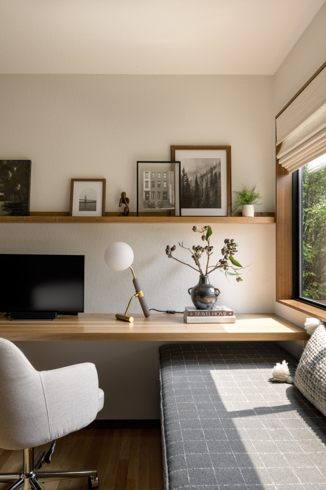 Example of a mid-sized trendy built-in desk medium tone wood floor study room design in Seattle with beige walls and no fireplace