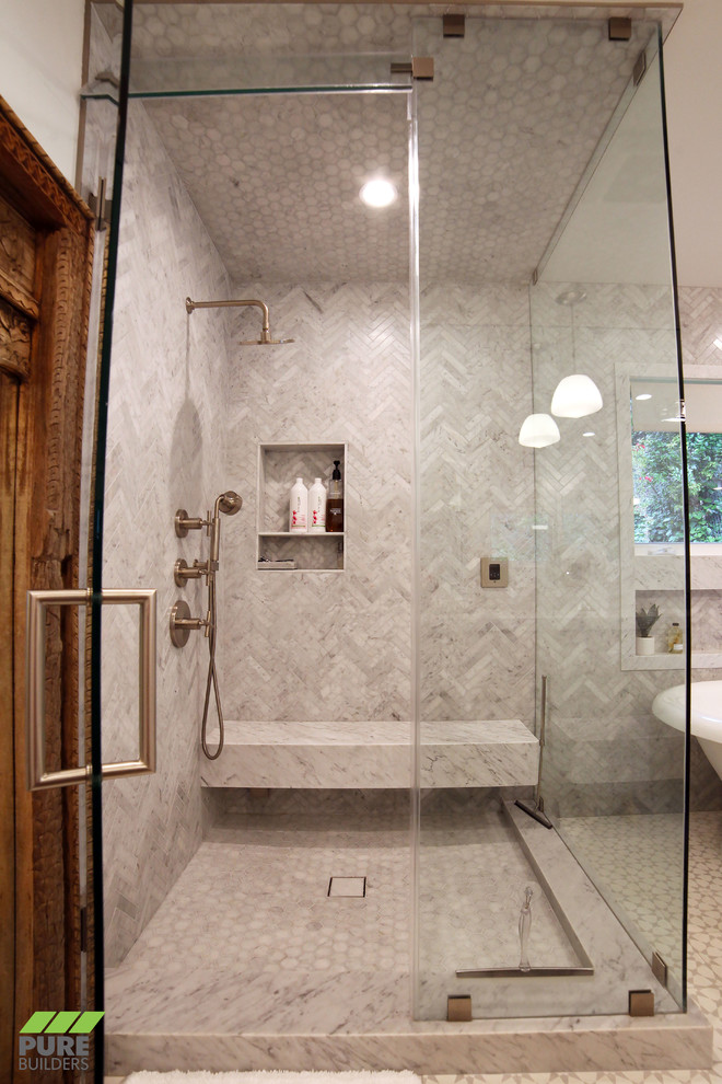 Photo of a large contemporary master bathroom in Los Angeles with flat-panel cabinets, medium wood cabinets, a freestanding tub, a corner shower, a bidet, marble, white walls, ceramic floors, an undermount sink, solid surface benchtops, multi-coloured floor, a hinged shower door and beige benchtops.
