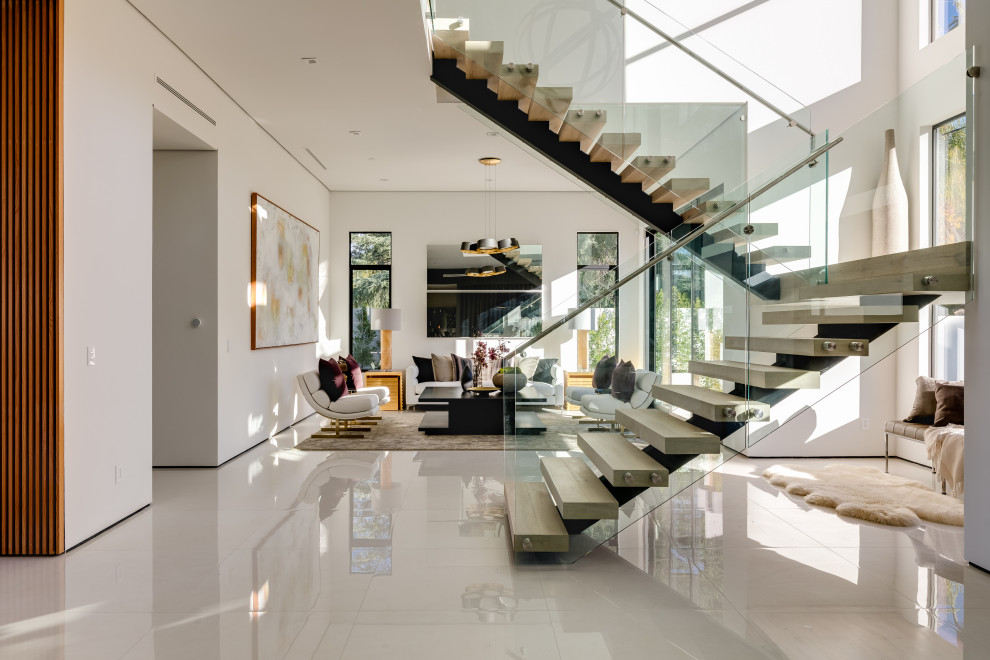 This is an example of an expansive contemporary metal l-shaped staircase in Los Angeles with wood risers and glass railing.
