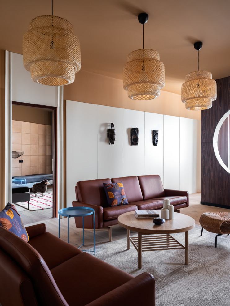 Стильный дизайн: гостиная комната в современном стиле с коричневыми стенами, паркетным полом среднего тона и коричневым полом - последний тренд