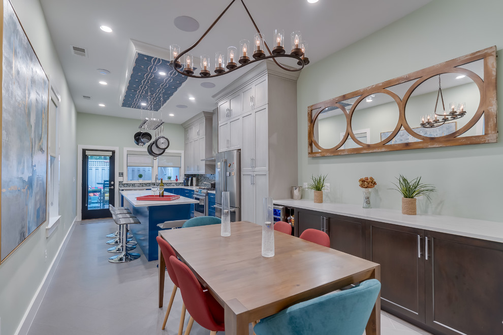 Mid-sized contemporary l-shaped eat-in kitchen in DC Metro with an undermount sink, blue cabinets, quartz benchtops, multi-coloured splashback, ceramic splashback, stainless steel appliances, porcelain floors, with island, grey floor, white benchtop and shaker cabinets.