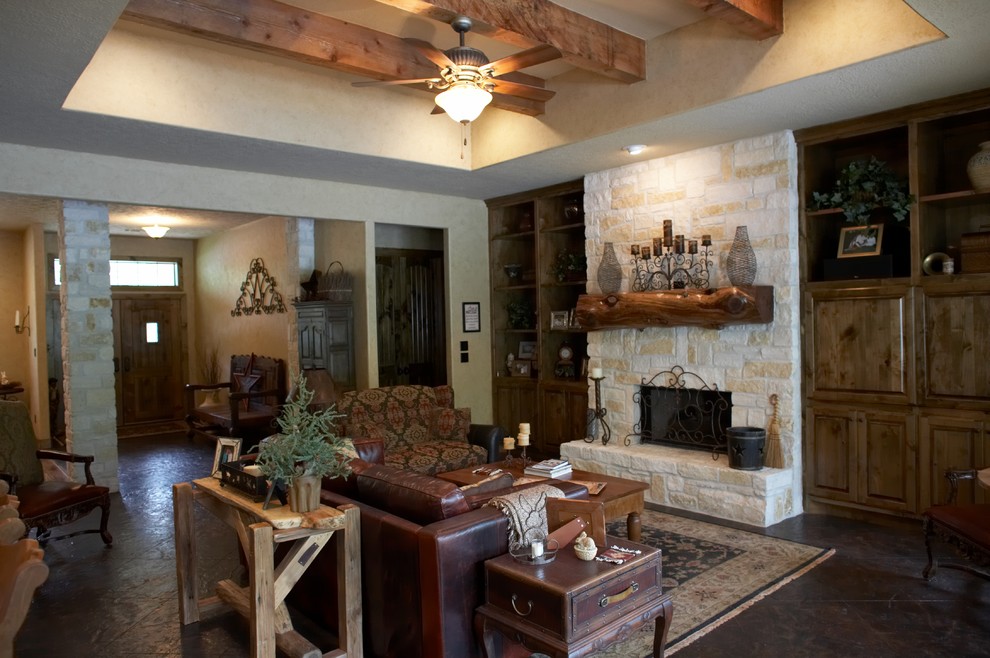 Inspiration for a mid-sized country enclosed living room in Houston with beige walls, concrete floors, a standard fireplace, a stone fireplace surround and a built-in media wall.