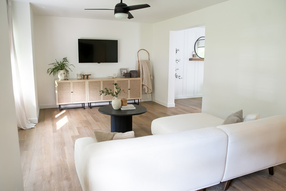 На фото: парадная, изолированная гостиная комната среднего размера в стиле ретро с белыми стенами, полом из винила, телевизором на стене и коричневым полом