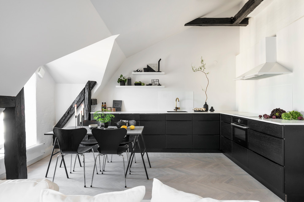 Design ideas for a large scandinavian l-shaped open plan kitchen in Stockholm with a single-bowl sink, flat-panel cabinets, dark wood cabinets, white splashback, light hardwood floors and no island.