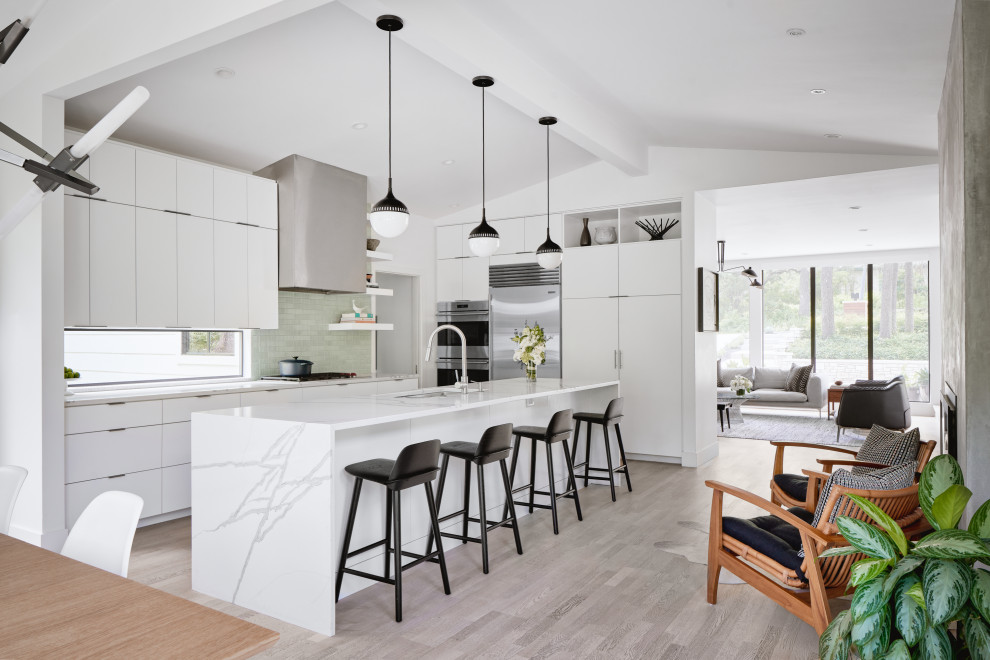 Design ideas for a small contemporary l-shaped eat-in kitchen in Austin with flat-panel cabinets, white cabinets, grey splashback, stainless steel appliances, light hardwood floors, with island, white benchtop, an undermount sink, grey floor and vaulted.