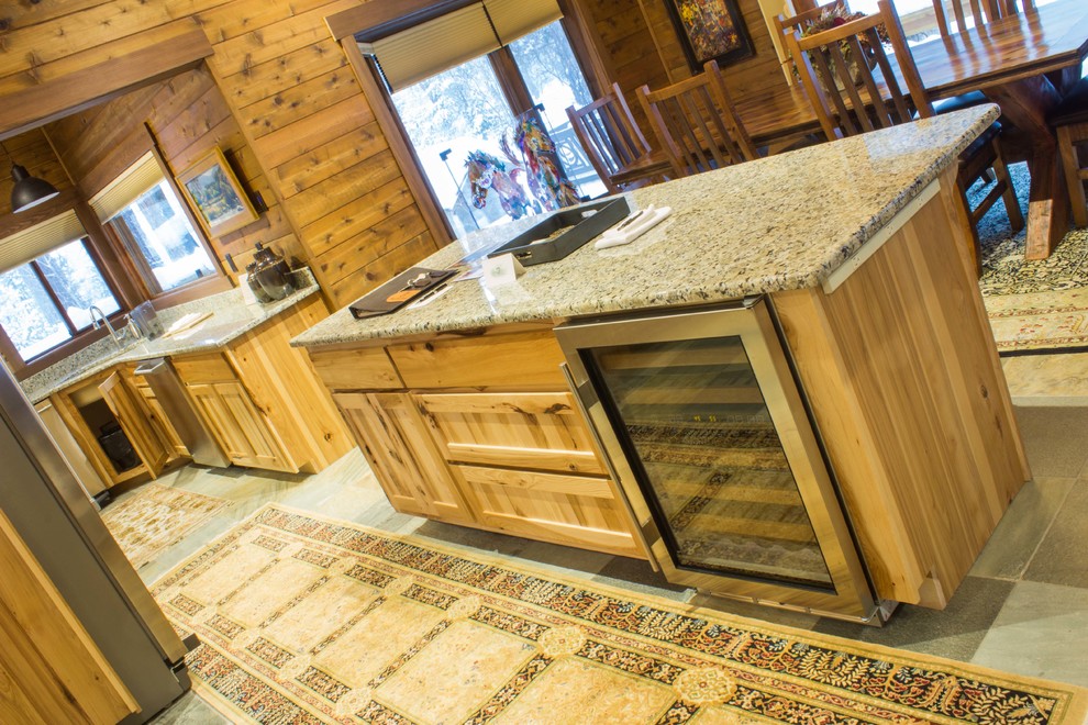 Inspiration for a mid-sized rustic l-shaped slate floor and gray floor eat-in kitchen remodel with flat-panel cabinets, medium tone wood cabinets, granite countertops, stainless steel appliances, an island and an undermount sink