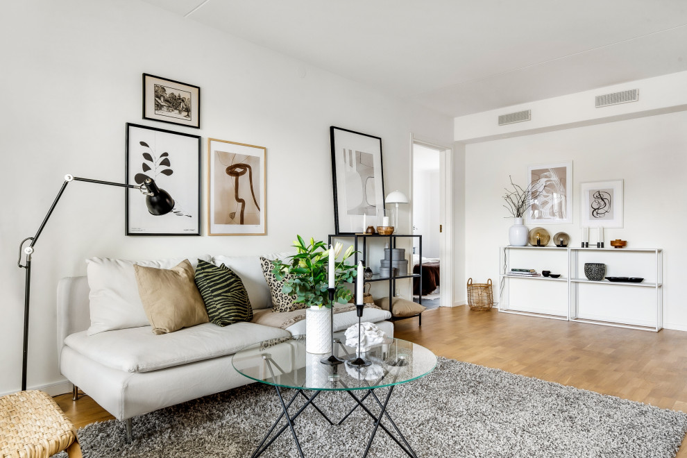 This is an example of a mid-sized scandinavian enclosed living room in Stockholm with white walls, medium hardwood floors and beige floor.