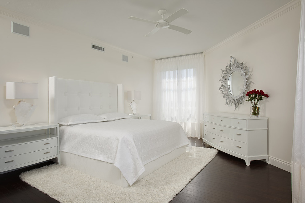 This is an example of a contemporary bedroom in Miami with white walls, dark hardwood floors and no fireplace.