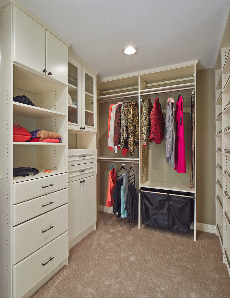 Photo of a transitional gender-neutral walk-in wardrobe in Dallas with white cabinets and carpet.