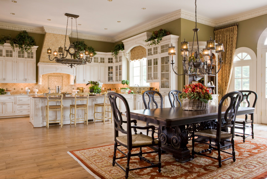 Example of a mid-sized mountain style l-shaped light wood floor and beige floor kitchen pantry design in DC Metro with raised-panel cabinets, beige backsplash, an island, white cabinets, granite countertops, a farmhouse sink, ceramic backsplash and paneled appliances