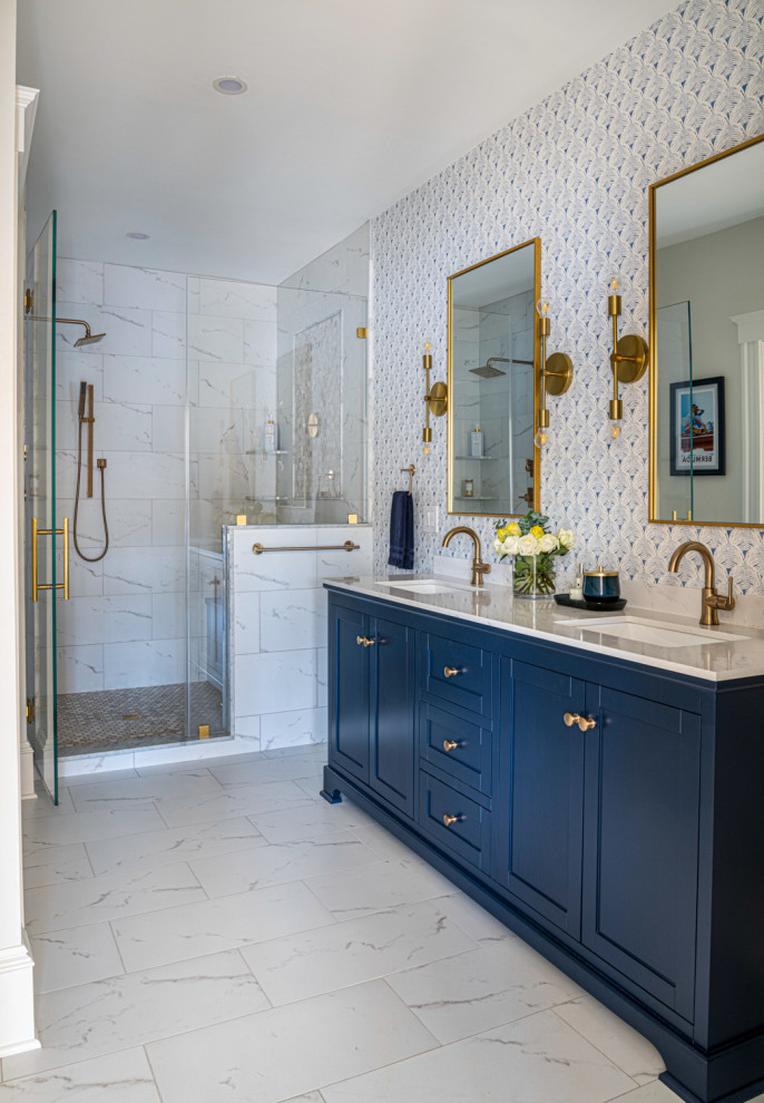 Стильный дизайн: большая главная ванная комната в стиле неоклассика (современная классика) с фасадами с утопленной филенкой, синими фасадами, ванной в нише, душем в нише, унитазом-моноблоком, серой плиткой, керамогранитной плиткой, серыми стенами, полом из керамогранита, врезной раковиной, мраморной столешницей, разноцветным полом, душем с распашными дверями, тумбой под две раковины, напольной тумбой и обоями на стенах - последний тренд