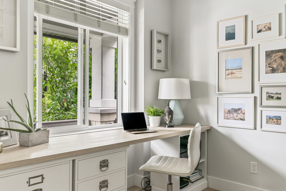 Example of a transitional built-in desk medium tone wood floor and brown floor home office design in Vancouver with gray walls
