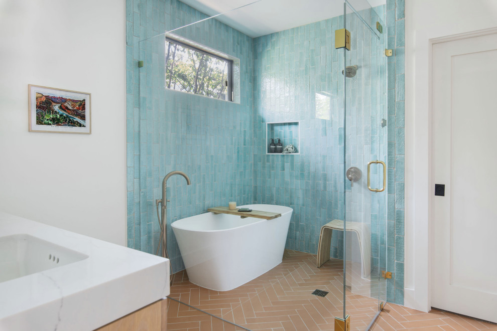 На фото: главная ванная комната среднего размера в стиле модернизм с плоскими фасадами, коричневыми фасадами, отдельно стоящей ванной, душевой комнатой, синей плиткой, керамической плиткой, белыми стенами, врезной раковиной, душем с распашными дверями, нишей, тумбой под две раковины, встроенной тумбой, столешницей из искусственного кварца, полом из терракотовой плитки, белой столешницей и кирпичными стенами