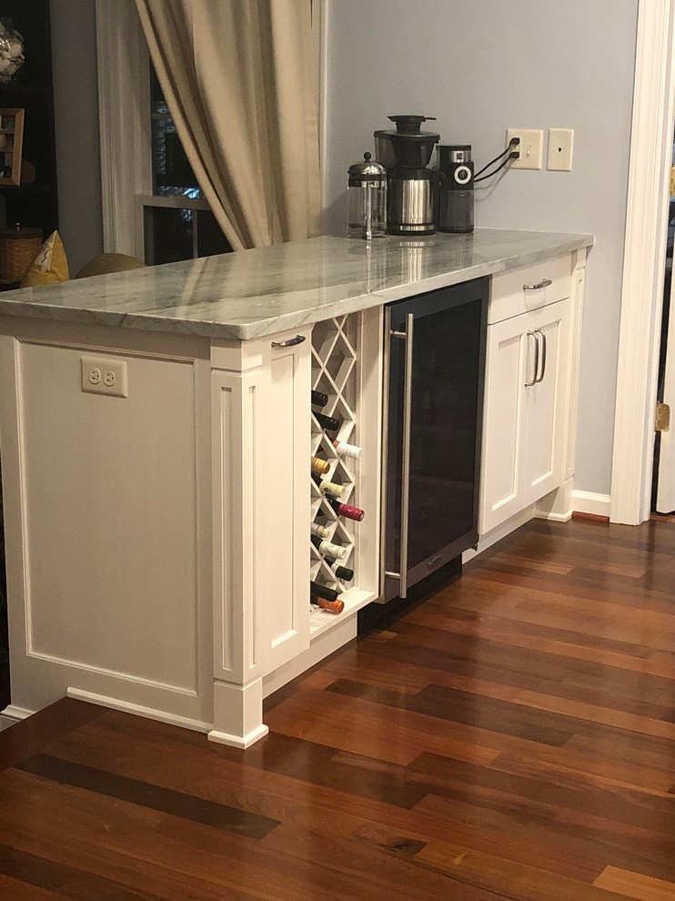 Eat-in kitchen - large transitional galley medium tone wood floor and brown floor eat-in kitchen idea in Baltimore with a single-bowl sink, recessed-panel cabinets, white cabinets, quartzite countertops, gray backsplash, glass tile backsplash, stainless steel appliances, an island and multicolored countertops