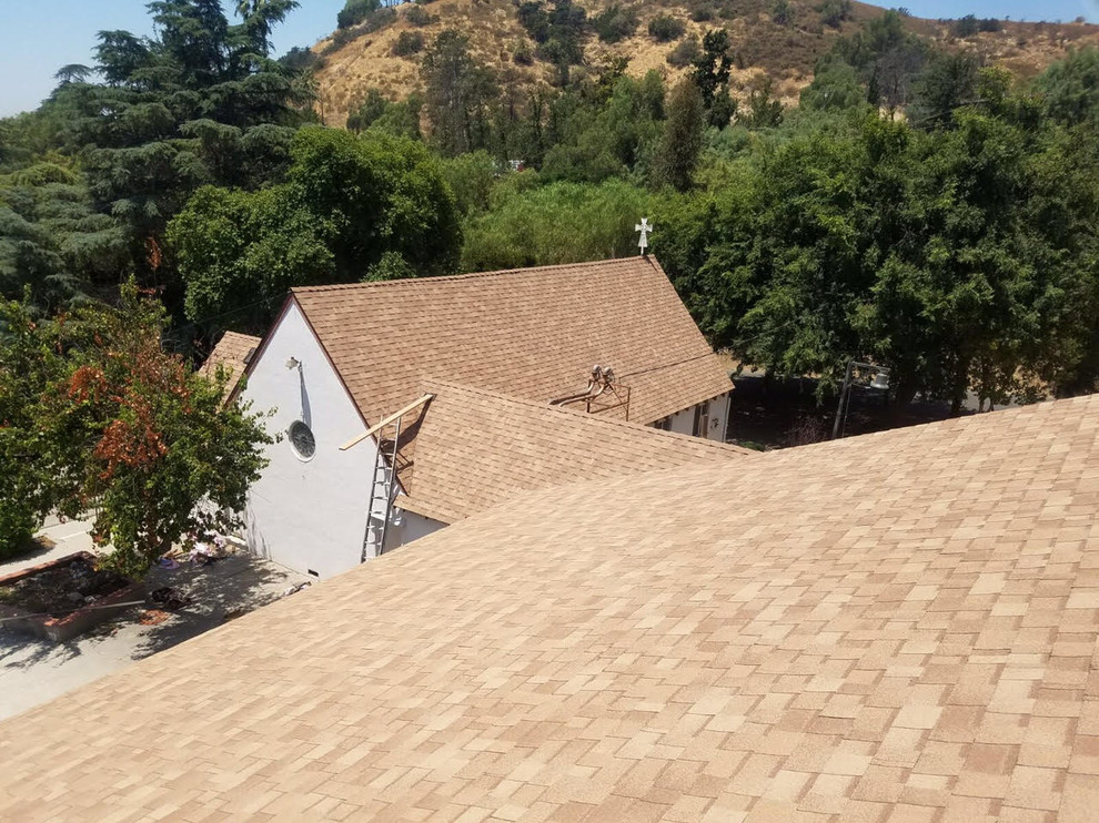 Large traditional two-storey stucco white house exterior in Los Angeles with a gable roof and a shingle roof.