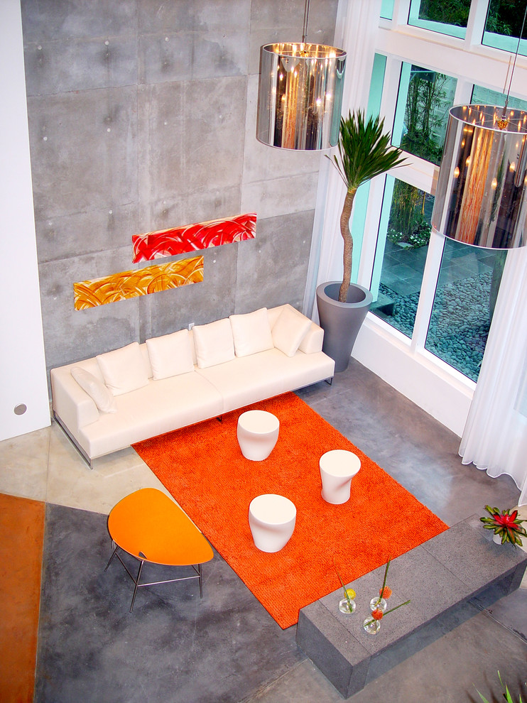 This is an example of a large contemporary formal open concept living room in Miami with grey walls and concrete floors.