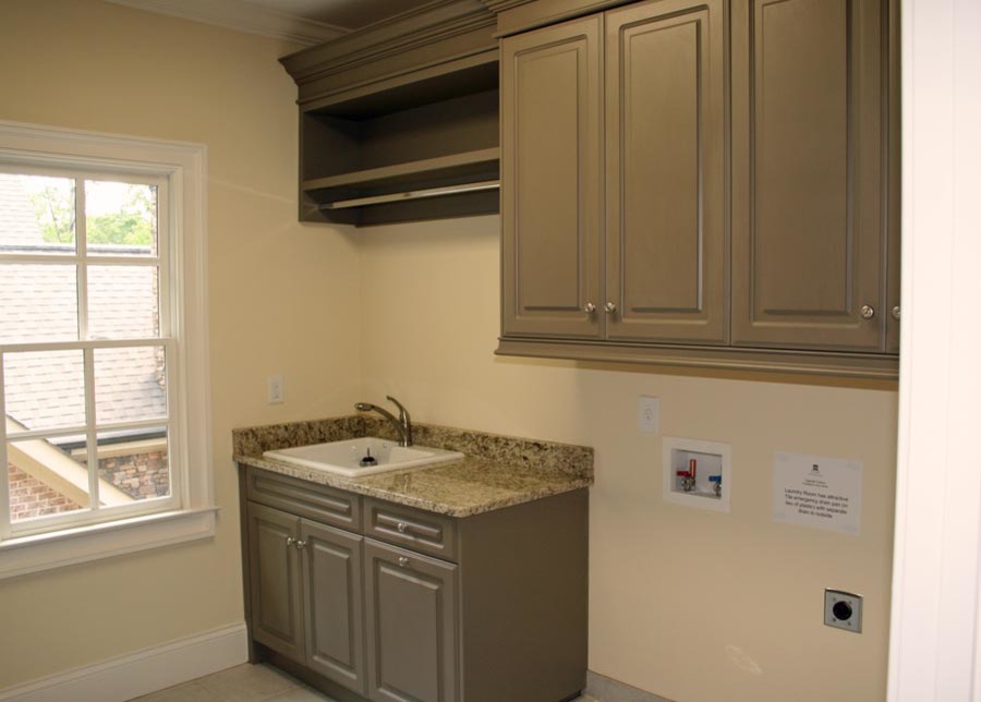 This is an example of a mid-sized traditional galley laundry room in Atlanta with a drop-in sink, grey cabinets, marble benchtops, beige walls, a side-by-side washer and dryer, raised-panel cabinets and ceramic floors.