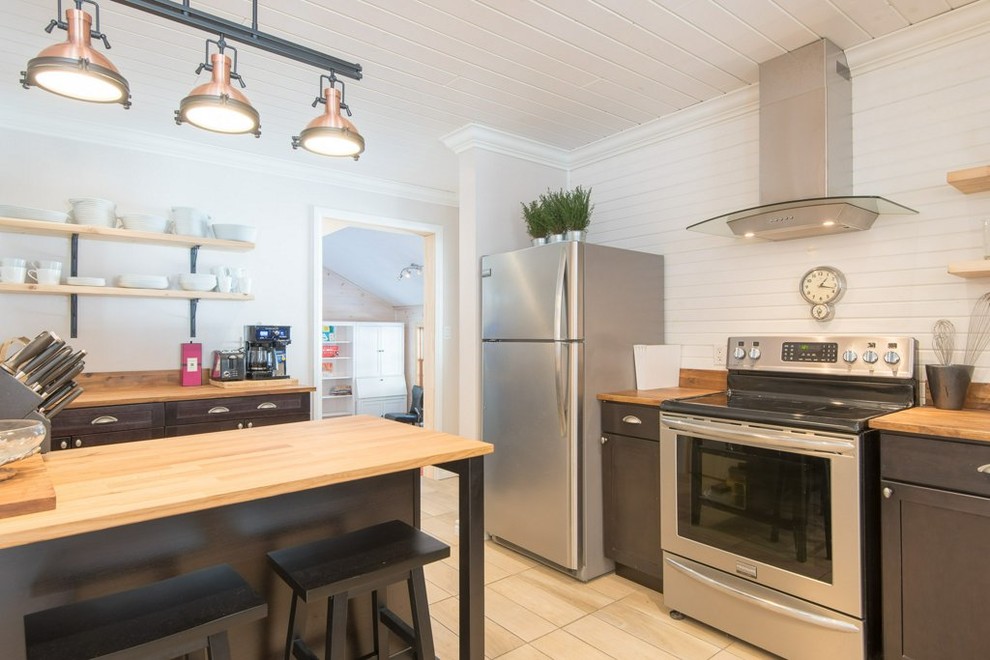 Kitchen - mid-sized rustic l-shaped ceramic tile and beige floor kitchen idea with a double-bowl sink, flat-panel cabinets, dark wood cabinets, wood countertops, white backsplash, wood backsplash, stainless steel appliances and an island