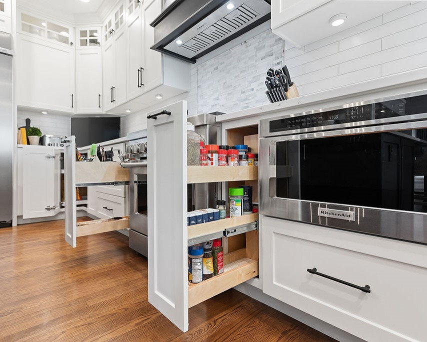 Large elegant l-shaped medium tone wood floor eat-in kitchen photo in Columbus with an undermount sink, recessed-panel cabinets, white cabinets, quartz countertops, white backsplash, quartz backsplash, stainless steel appliances, an island and white countertops