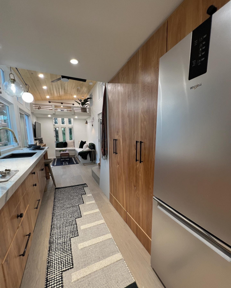 Photo of a medium sized contemporary galley open plan kitchen in Hawaii with a submerged sink, flat-panel cabinets, medium wood cabinets, granite worktops, white splashback, granite splashback, stainless steel appliances, light hardwood flooring, no island, beige floors, white worktops and a timber clad ceiling.