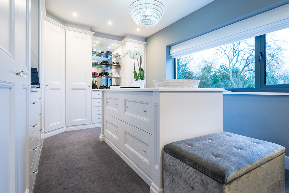 Inspiration for a mid-sized traditional gender-neutral walk-in wardrobe in Oxfordshire with white cabinets, carpet, grey floor and recessed-panel cabinets.