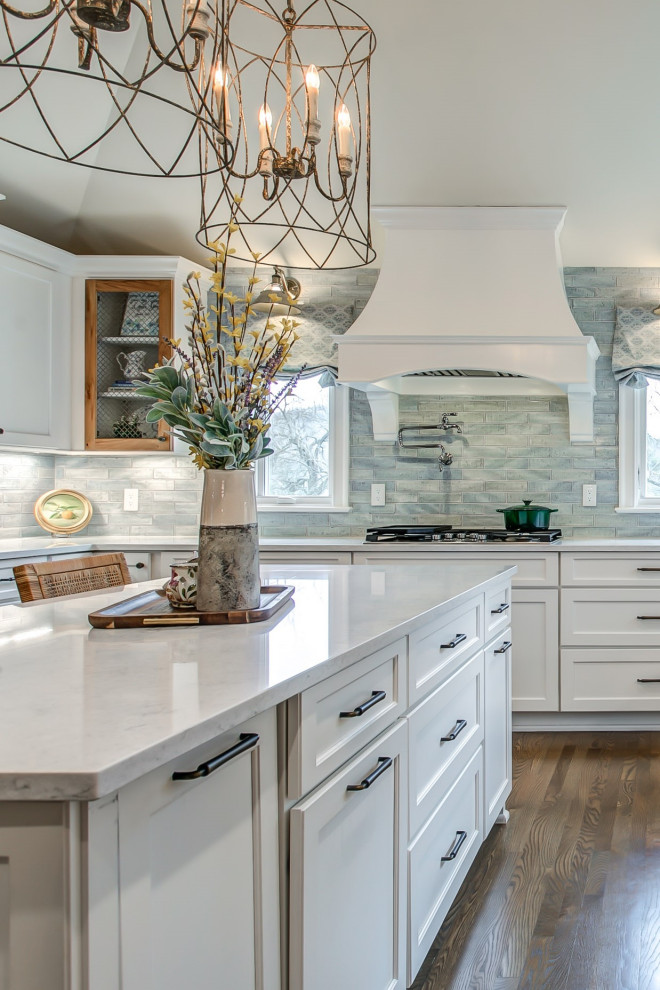 Foto di una grande cucina con ante in stile shaker, ante bianche, paraspruzzi blu, pavimento in legno massello medio, pavimento marrone e top bianco
