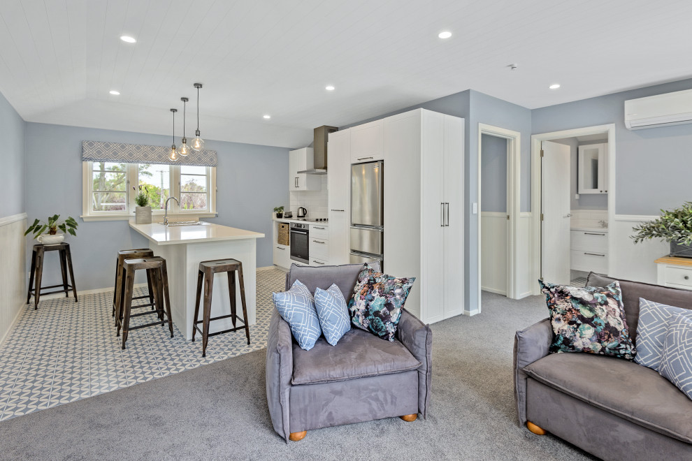 Стильный дизайн: открытая гостиная комната среднего размера в классическом стиле с синими стенами, ковровым покрытием, синим полом, сводчатым потолком и панелями на стенах - последний тренд