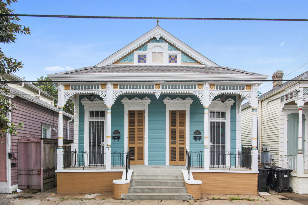 Inspiration for a small eclectic one-storey blue duplex exterior in New Orleans with vinyl siding, a gable roof and a shingle roof.