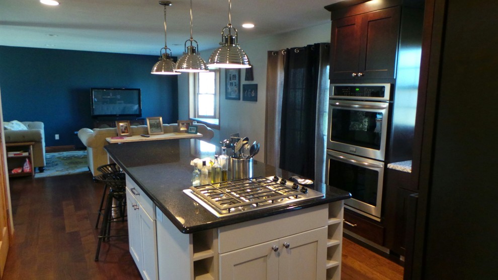 Design ideas for a mid-sized transitional l-shaped open plan kitchen in Minneapolis with an undermount sink, shaker cabinets, dark wood cabinets, granite benchtops, grey splashback, glass tile splashback, stainless steel appliances and with island.