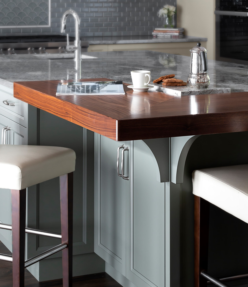 Example of a large transitional l-shaped dark wood floor, brown floor and exposed beam eat-in kitchen design with a single-bowl sink, shaker cabinets, beige cabinets, granite countertops, blue backsplash, glass tile backsplash, paneled appliances, an island and multicolored countertops