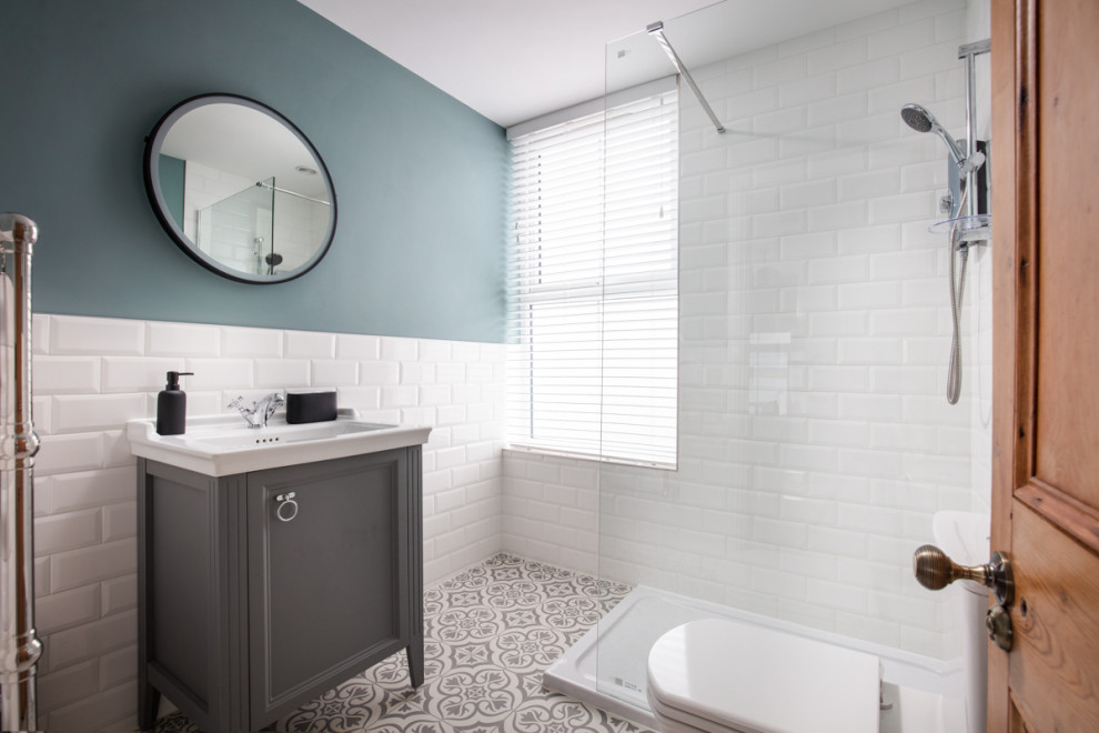 Пример оригинального дизайна: маленькая ванная комната: освещение в викторианском стиле с фасадами с выступающей филенкой, серыми фасадами, открытым душем, инсталляцией, белой плиткой, плиткой кабанчик, зелеными стенами, полом из керамогранита, душевой кабиной, консольной раковиной, столешницей из искусственного камня, серым полом, открытым душем, белой столешницей, тумбой под одну раковину и напольной тумбой для на участке и в саду