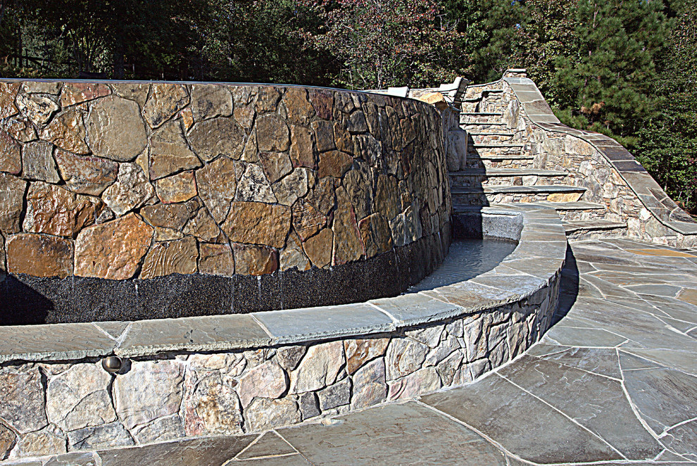Design ideas for a large rustic full sun backyard stone retaining wall landscape.