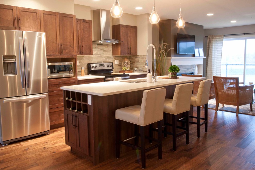 Example of a mid-sized transitional single-wall medium tone wood floor open concept kitchen design in Edmonton with a double-bowl sink, shaker cabinets, medium tone wood cabinets, gray backsplash, glass tile backsplash, stainless steel appliances and an island