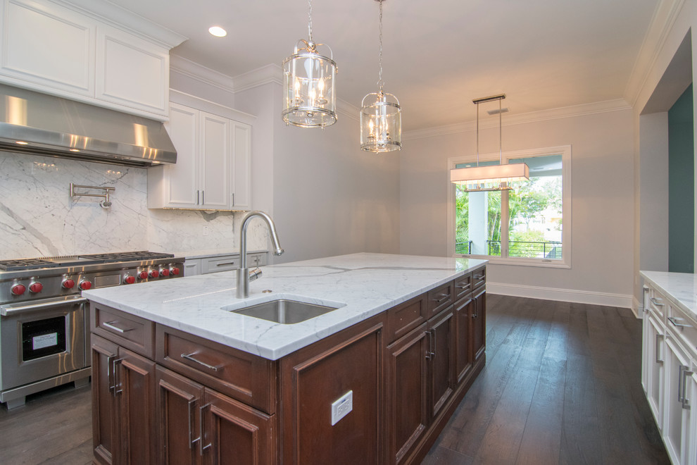 Enclosed kitchen - large transitional u-shaped dark wood floor and brown floor enclosed kitchen idea in Tampa with an undermount sink, recessed-panel cabinets, white cabinets, marble countertops, gray backsplash, marble backsplash, stainless steel appliances and an island