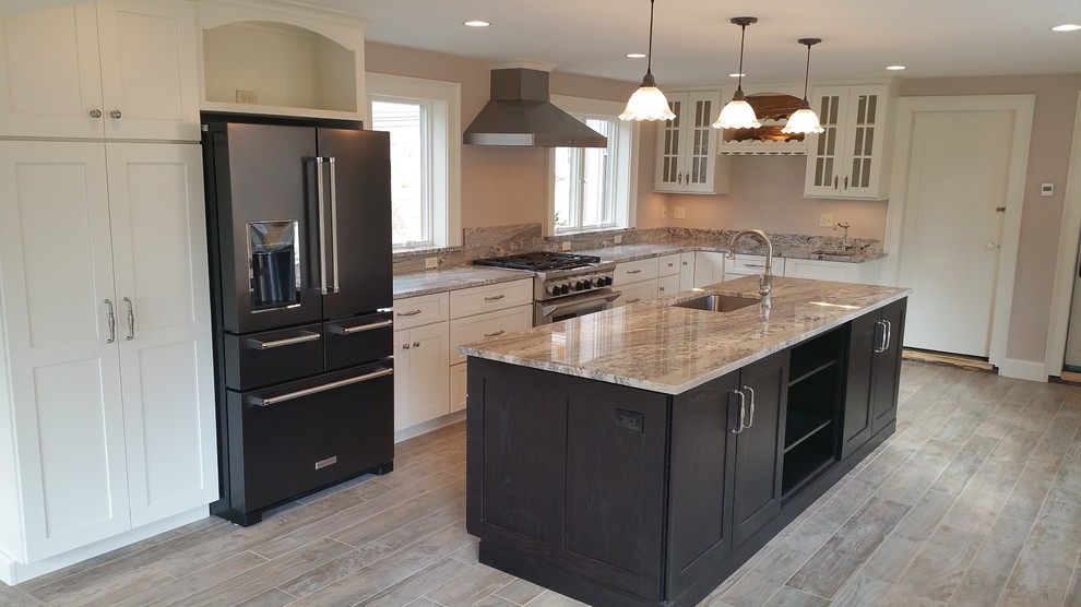 Large traditional l-shaped eat-in kitchen in Bridgeport with an undermount sink, flat-panel cabinets, white cabinets, granite benchtops, stainless steel appliances, porcelain floors and with island.